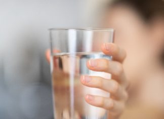 Person holding glass of water