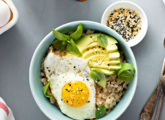 Savory oatmeal with sunny side up egg and avocado for breakfast overhead