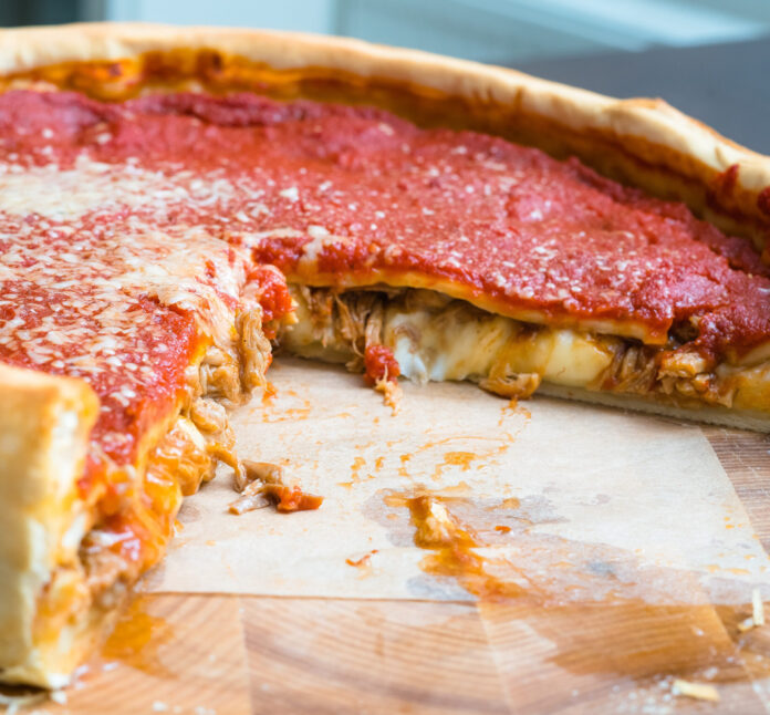 Top view of Chicago pizza. Chicago style deep dish italian cheese pizza with tomato sauce and beef meet inside