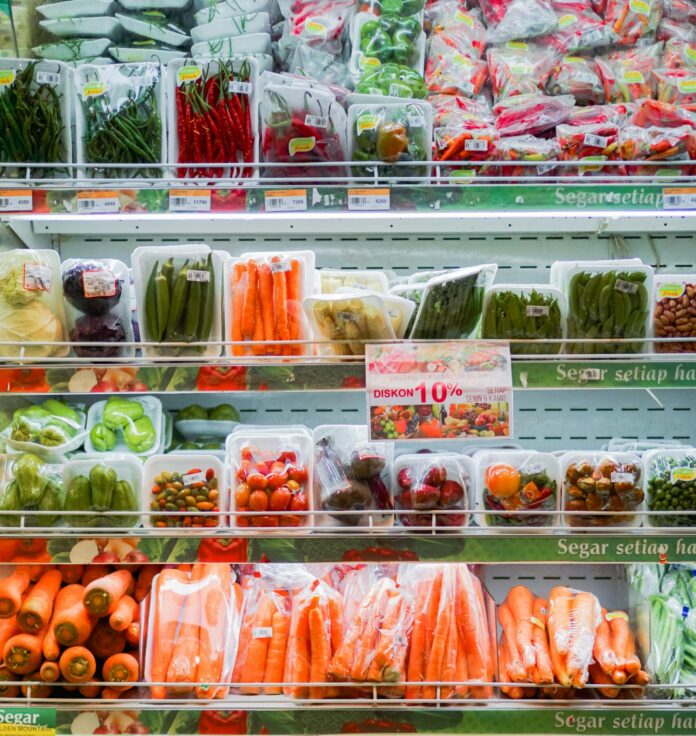 Packaged vegetables on refrigerator shelves at grocery stores