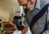 Elderly Man Slicing a Banana on a Chopping Board