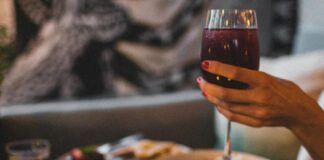 Crop unrecognizable woman with delicious dishes and wine in restaurant